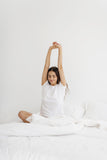 Woman stretching in bed.