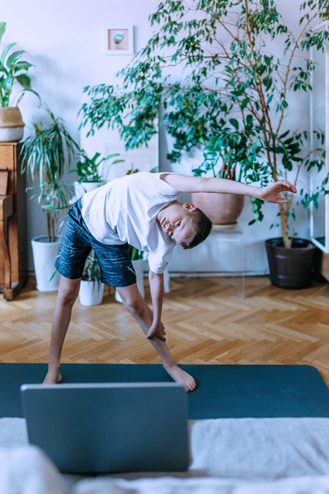 Young boy doing exercises at home. 