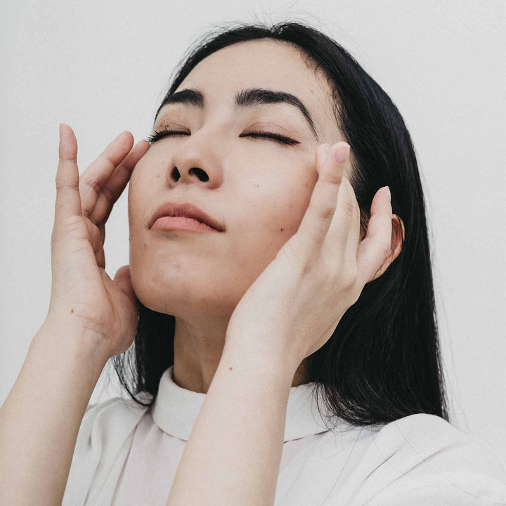 Why jaw clenching and how to fix it with woman massaging temples.