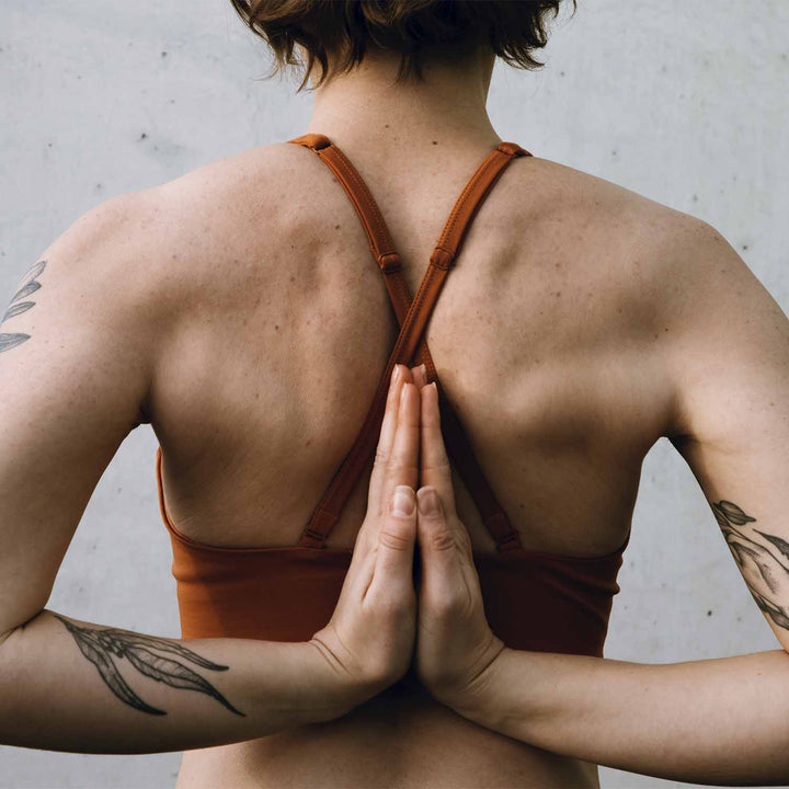 How shoulders should look with woman holding hands behind back.